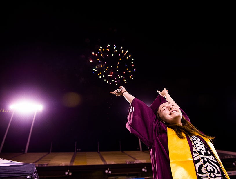 ASU graduate celebrating night sky with fireworks