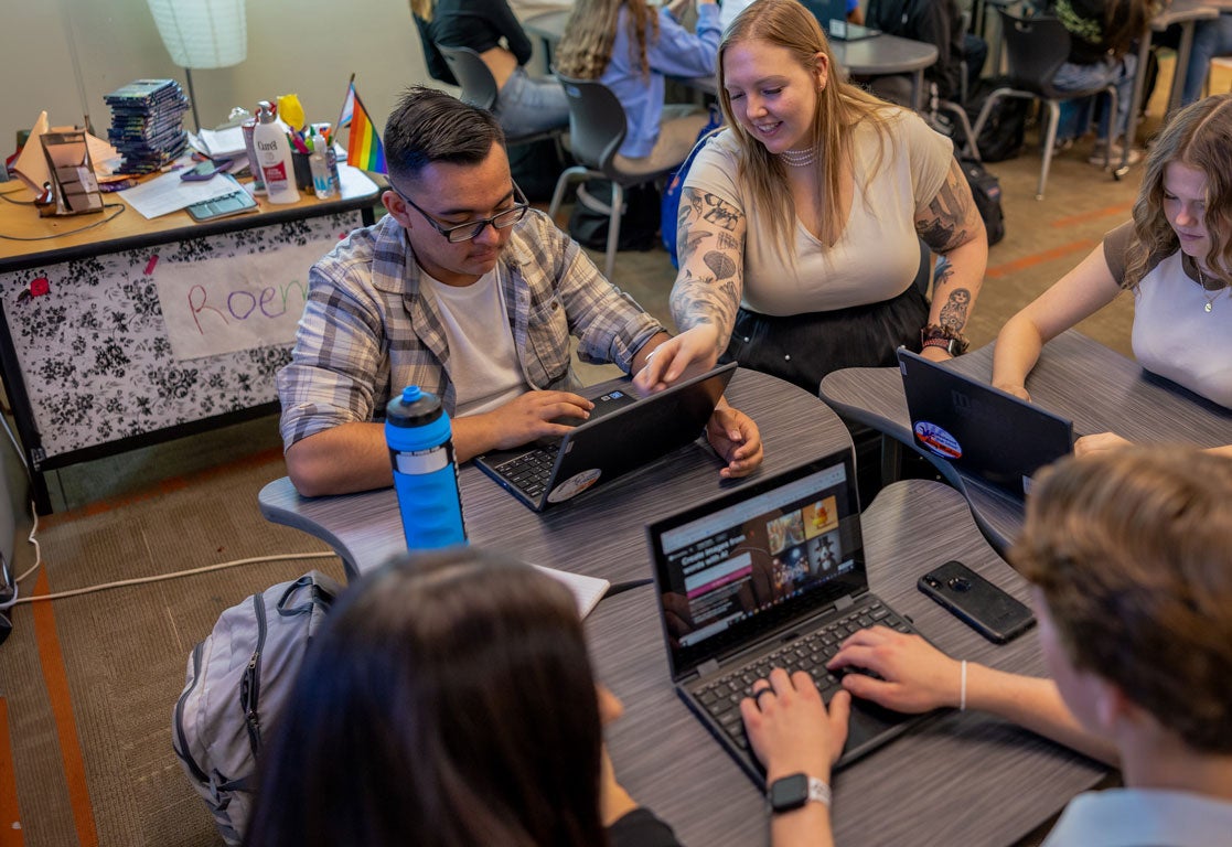 teacher mentoring students in a classroom