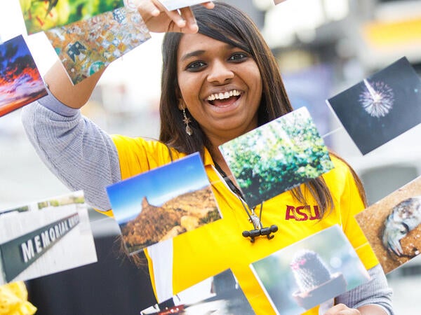 Image of a student standing in front of a string with photos hanging off it