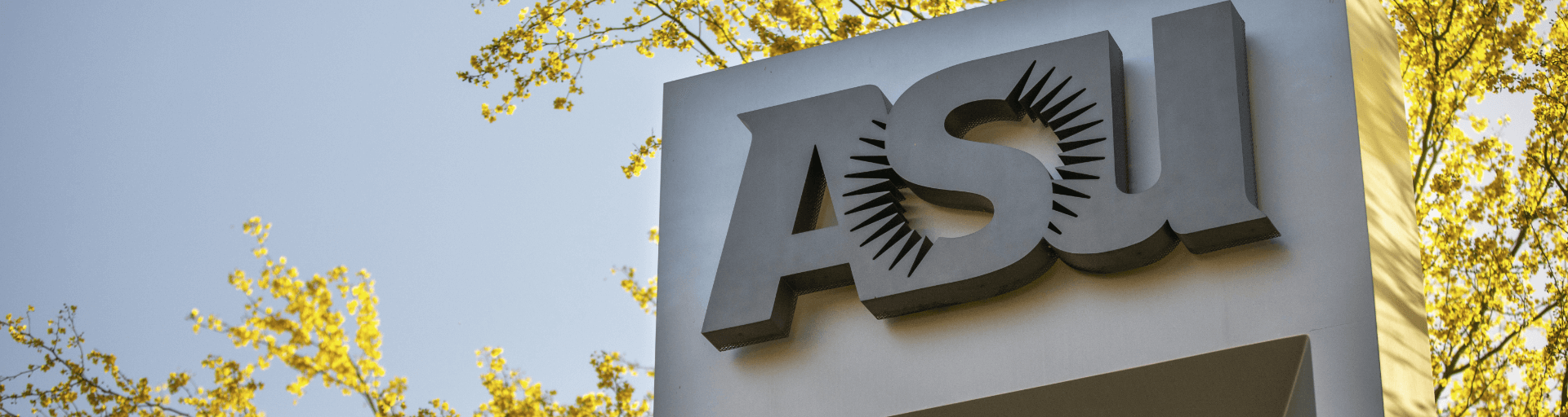ASU sign on campus with gold leaves and blue sky in the background