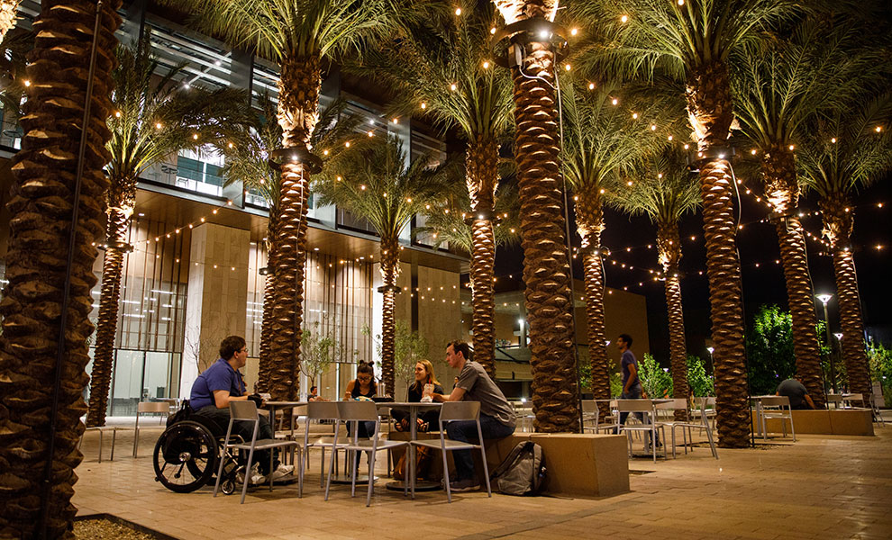 students meeting in a courtyard at night