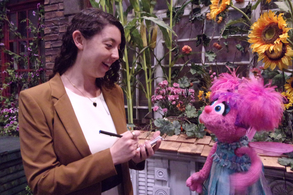 Image of Kathryn Ostrofsky next to a Sesame street character